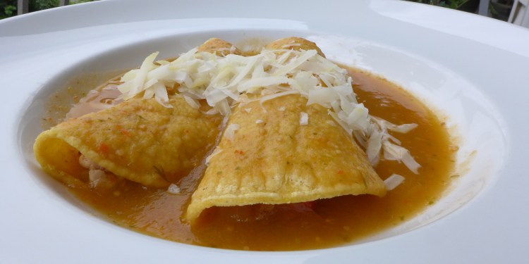 plate of Mexican enchiladas with green tomatillo sauce